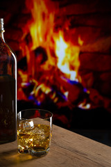 Glass of whiskey in front of a fireplace