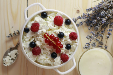 Composition with cottage cheese, fresh berries and yogurt on wooden table