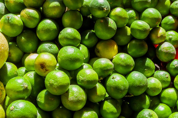 Street sale of green organic lemons, which the sunlight reaches strongly in Street market in Guanabano Bridge in La Baralt Aveneu, Caracas, Venezuela.