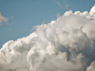 The sky with beautiful cumulus clouds. Restrained pastel colors.