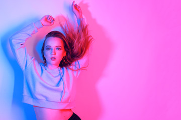 Fashion portrait of young elegant girl.Colored neon background, studio shot. Beautiful brunette...