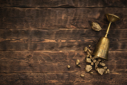 Golden Cup Award With A Scattered Gold On A Brown Wooden Table Background With Copy Space.