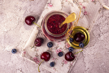 Smoothie jam of sweet cherry and bluberry in glass jar. Top view