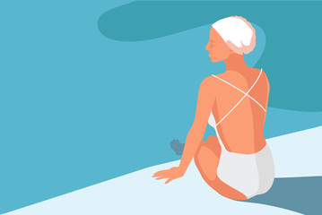 A young woman in the swimsuite is sitting beside the pool