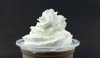 Close up Whip cream on Cocoa smoothie Black background, Food concept Front view.