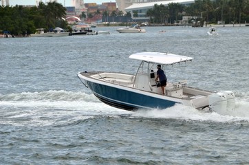 Fototapeta premium Small sport fishing boat speeding by Monument Island off Miami Beach,Florida