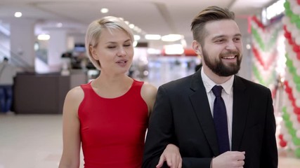 Young attractive couple with shopping bag walk in a mall. smiling feel happy shopper family