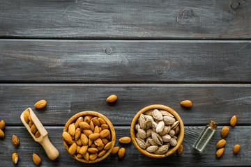 Almond in bowls for cooking oil on wooden background top view mockup