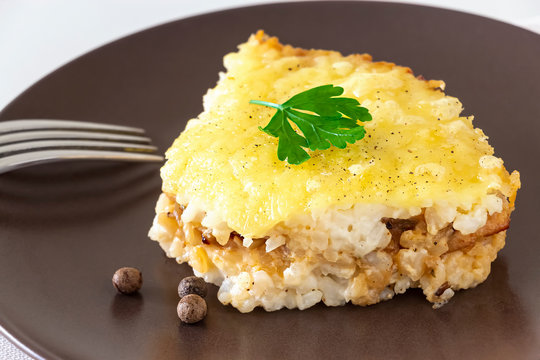 Casserole or rice and cheese pie with minced meat. Healthy dietary lunch or dinner. White background. Copy space.