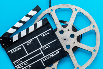 Go to the cinema with film type and clapperboard on blue background top view