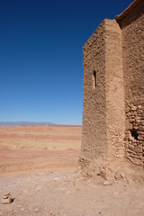 high brown wall of Ancient Kasbah in Ait-Ben-Haddou, Morocco. Gradient blue skyline background