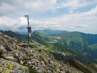 Top of the peak Banikov at Western Tatra mountains or Rohace. Sharp green mountains - ostry rohac, placlive and volovec with hiking trail on ridge. Summer blue sky white clouds. - obrazy, fototapety, plakaty