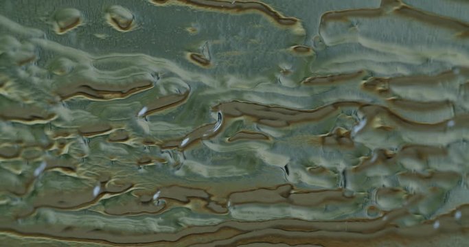 Macro shot of acrylic glass with abstract figures on it. Camera tilts up.