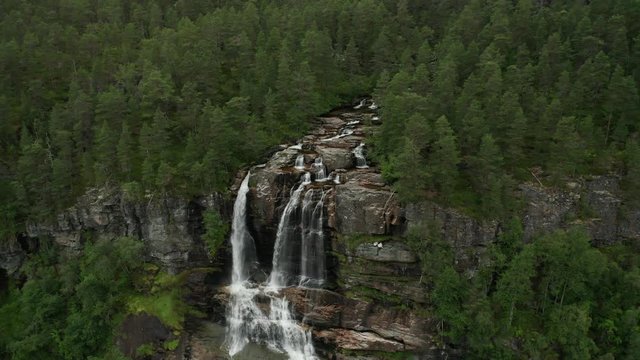 Impressive Cliff Waterfall in Norway Evegreen Forest. Landscape Rising Aerial