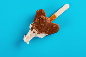 top view mostly eaten chocolate outer popsicle on blue background