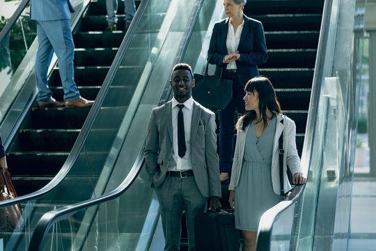 Diverse Business People Interacting With Each Other While Using Escalators In Modern Office 