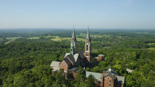 Holy Hill National Shrine of Mary, Wisconsin, USA, aerial view forward flight over Basilica through spires drone footage.