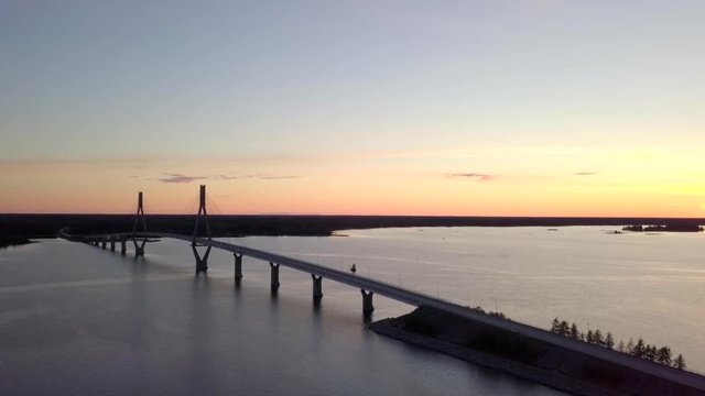 Aerial, tracking, drone shot, towards the Raippaluodon silta bridge, at sunset, in the Kvarken archipelago, on a sunny, summer evening, in,Vaasa, Ostrobothnia, Finland