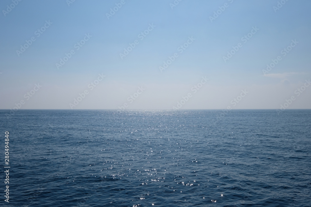 Wall mural wide deep blue sea horizon. peaceful ocean with sunlight reflection. simplicity.