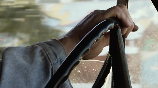 Close Up of Male Hands Holding On a Steering Wheel of Old Retro Car. Side View. 