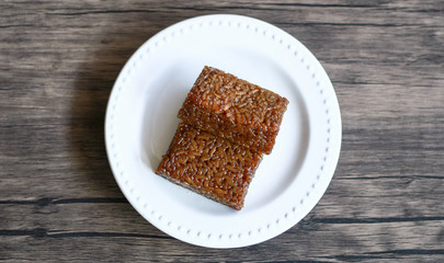 Wajik on wood background.  Wajik is traditional snack made with steamed glutinous (sticky) rice and further cooked in palm sugar, coconut milk, and pandan leaves.