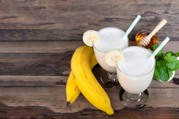 Banana fresh cocktail vanilla smoothies juice and white banana fruit beverage healthy the taste yummy In glass for for milkshake on wooden background.