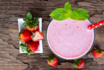 Strawberry smoothies colorful fruit juice milkshake blend beverage healthy high protein the taste yummy In glass,drink episode morning on wood background from the top view.