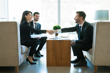 Entrepreneurs Sealing The Deal With Handshake In Hotel