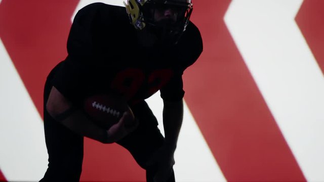 Caucasian male American football player posing against animation on a huge bright screen. Shot on ARRI Alexa Mini in 4K RAW