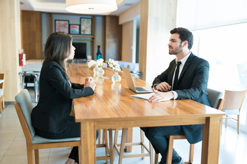 Businesswoman Explaining Business Model To Entrepreneur In Hotel