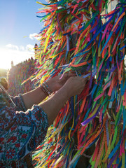 Hands tying Colorful ribbons on grid in front of Bonfim Church in Salvador, Bahia, Brazil
