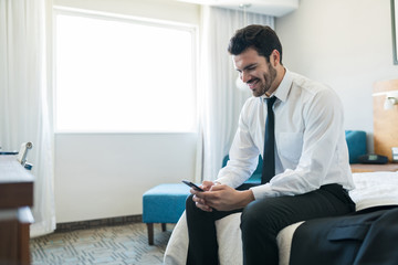 Executive With Smartphone In Hotel Room