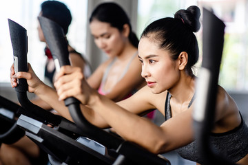 Fototapeta na wymiar Young healthy woman bike cardio at the gym