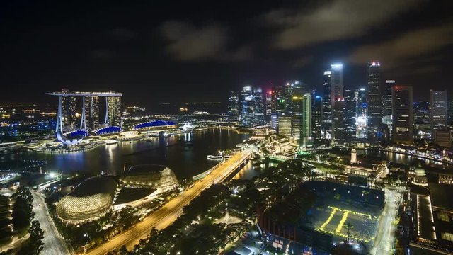 4k aerial time lapse of night scene at Singapore city skyline. Zoom out