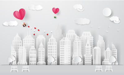 Paper art , cut and Carving design of Lover in the park.Valentine's day vector illustration paper cut style background.Love couple in origami heart shape hot air balloon flying on sky over cityscape.