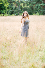 Fototapeta na wymiar Girl in a gray dress in the field