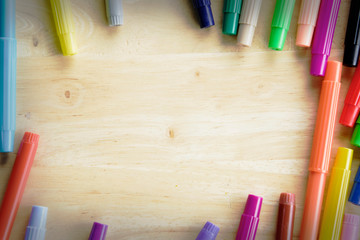 Obraz premium Colorful pen on wooden table background with space.