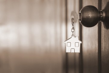 Home key with house keyring in keyhole on wooden door - 280508860