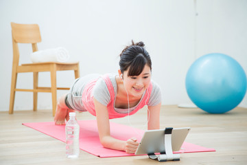 タブレットを見てトレーニングをする女性