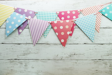 Obraz premium Colorful Bunting hanging with space copy on wooden background