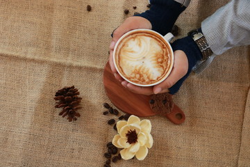 a cup of cappucino coffe on a table ready to drink