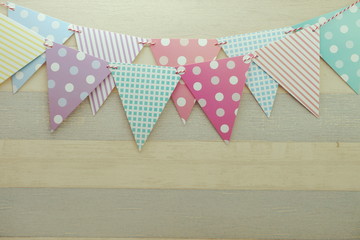 Obraz premium Colorful Bunting hanging with space copy on wooden background