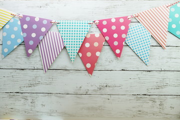 Obraz premium Colorful Bunting hanging with space copy on wooden background