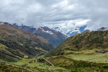 Green valley surrounded by mountains in clouds, Choquequirao trek between Yanama and Totora, Peru