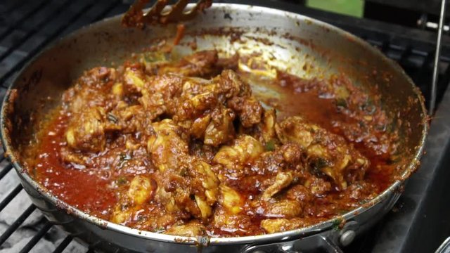 Cooking Tava chicken or skillet Chicken , an appetizer outdoors in a pan on coal