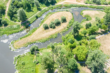 beautiful park scene with trees, green lawns and river in summer, aerial top image