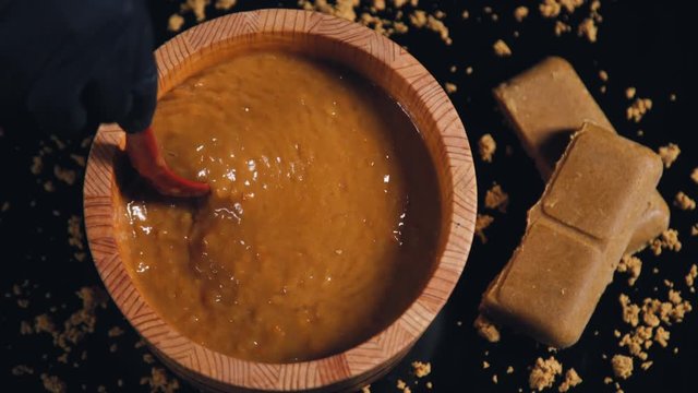Someone is mixing curry with a spoon. Japanese curry on the black background top view. Food video. Asian food. Asian cuisine. Cooking curry.