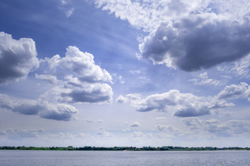 Naklejka na ściany i meble Minimalist landscape of small patch of water under vast beautiful sky with clouds