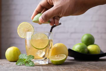 hand squeezing lemon juice and sliced lemon, concept of healthy care.