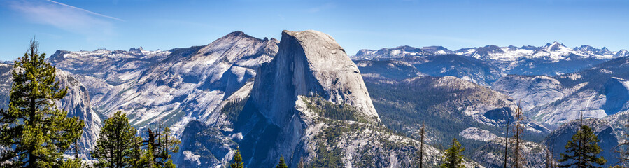 Panoramic view of the majestic Half Dome and the surrounding wilderness area with mountain peaks...